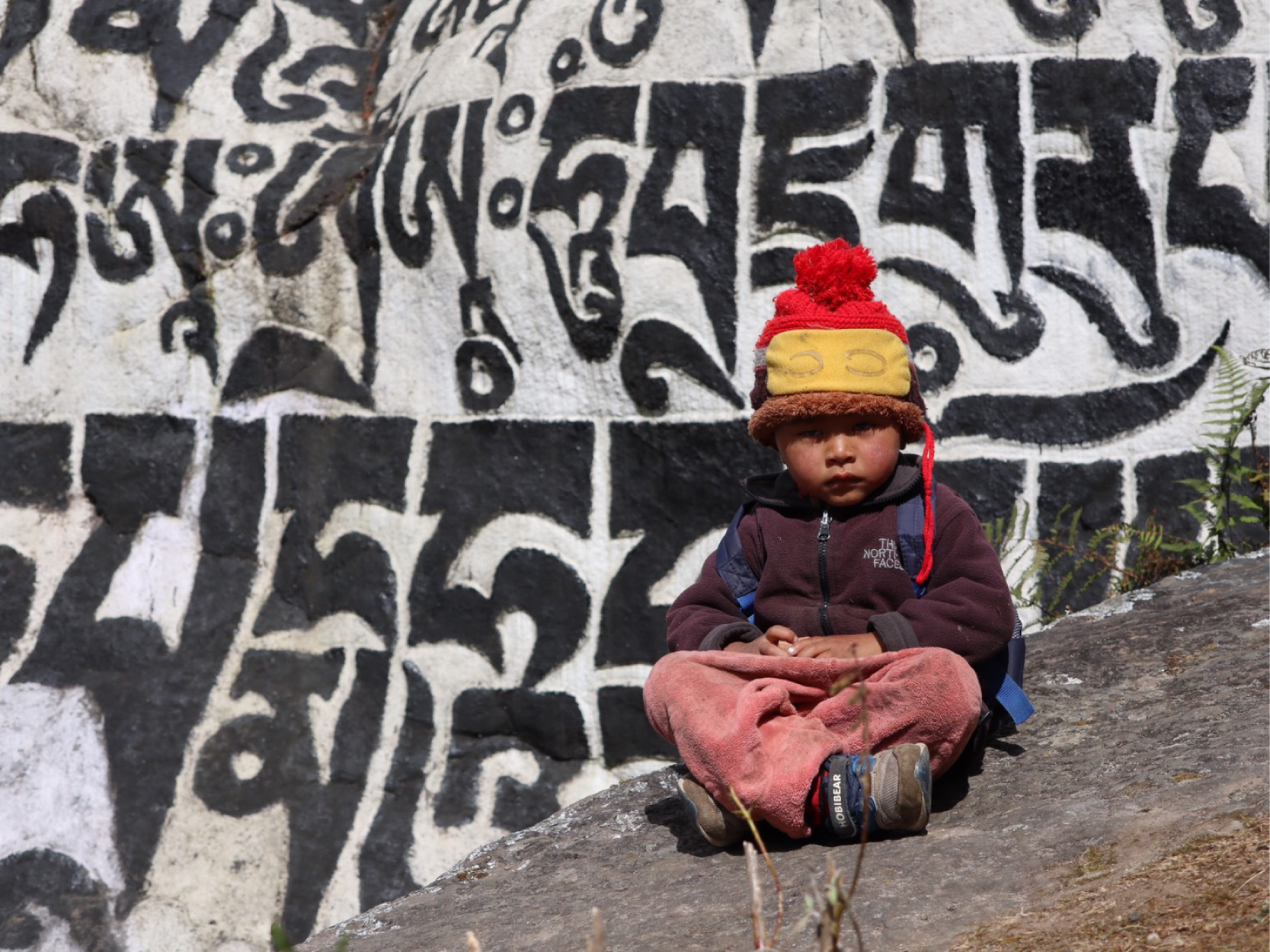 写真11_マニ石の前に座るシェルパの子供